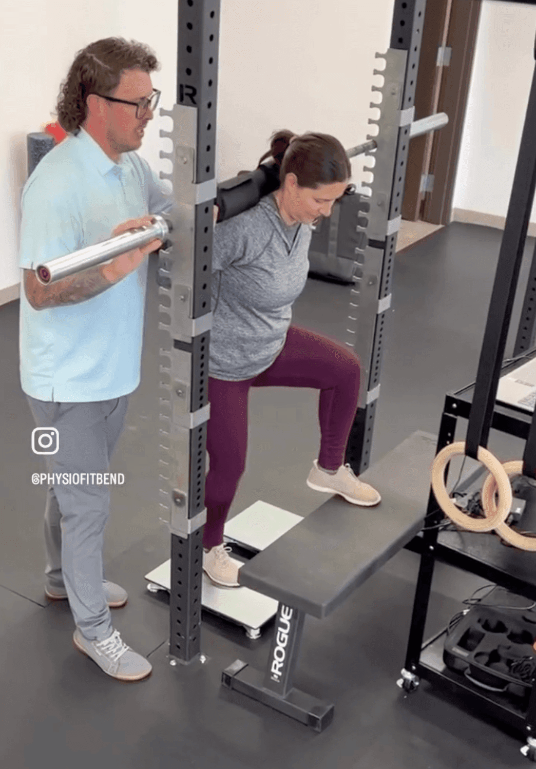 A CrossFit athlete coached through a loaded barbell step-up at PhysioFIT in Bend, Oregon
