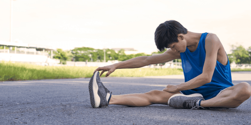 Man stretching his legs outside.
