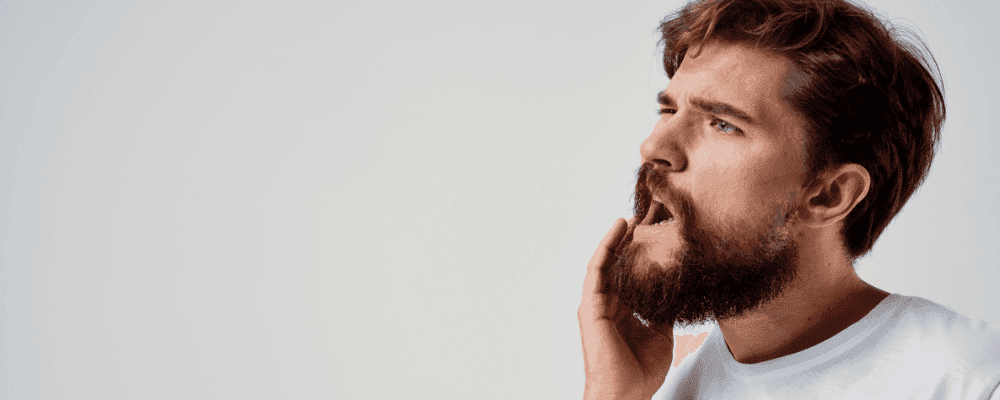 Man touching his jaw in pain.