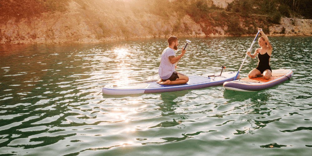 Man and woman on paddle boards on the lake.