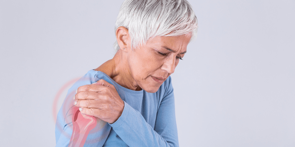Woman holding her shoulder in pain.