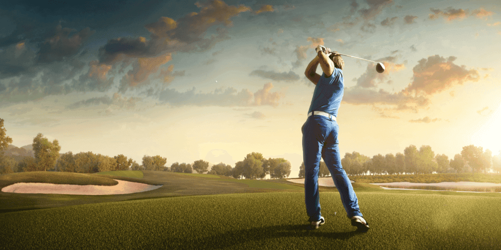 Man holding a driver in mid swing on a golf course.